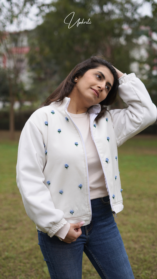 Chaqueta de lana blanca con flores azules.